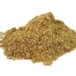 Pile of brown ground spice powder on white